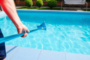 Worker Make Maintenance Of Swimming Pool. Male Hand Hold Pool Net Cleaner.